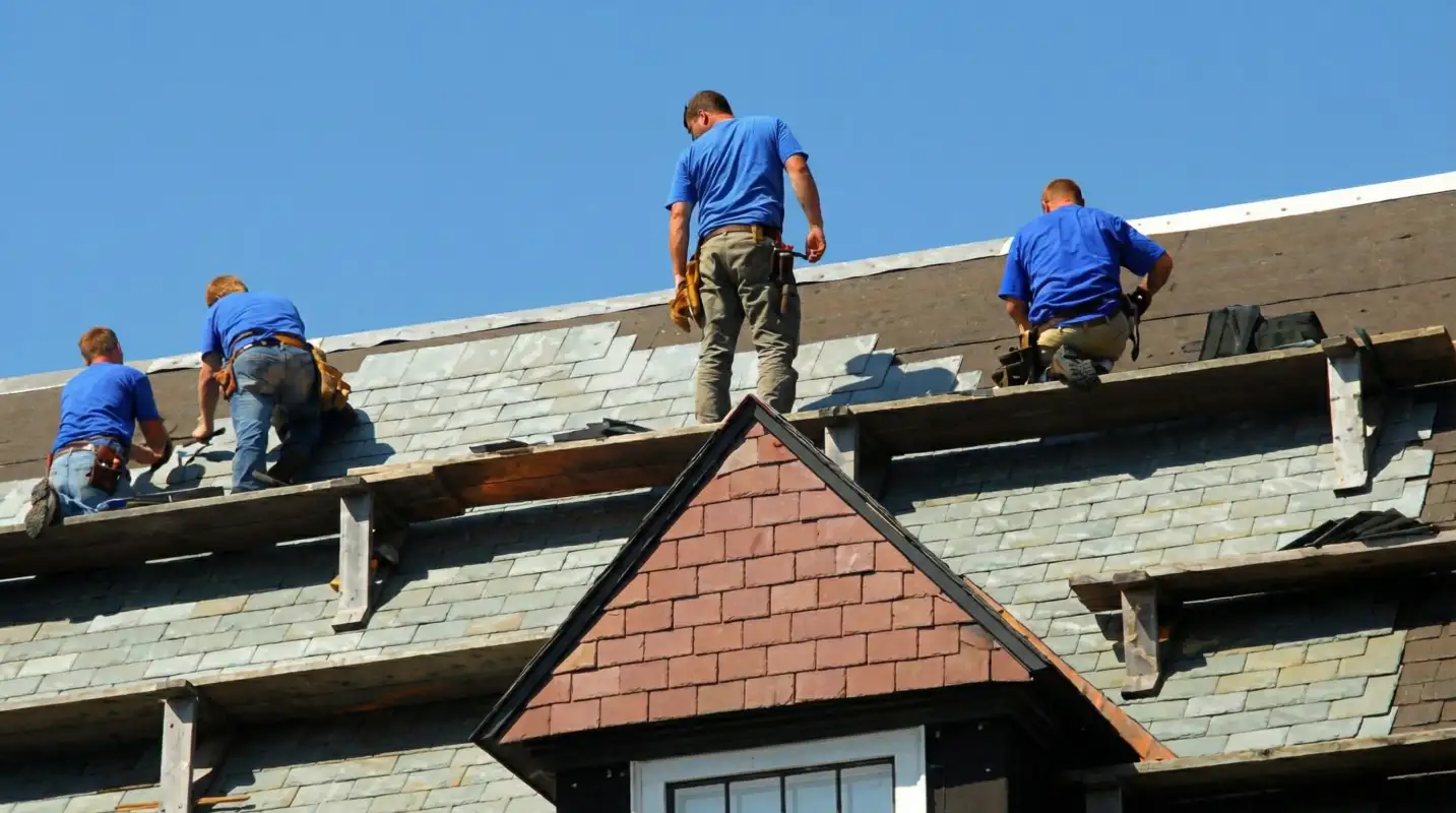 Roof replacement in progress with a team of professional contractors installing new shingles on a residential home in Mobile, AL